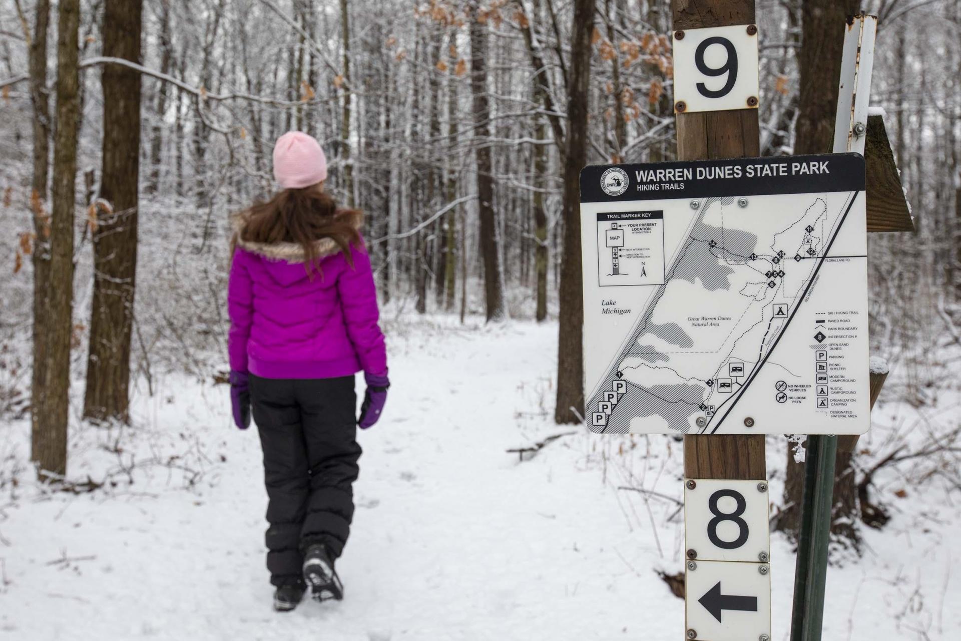 A person hiking at Warren Dunes State Park in the winter.