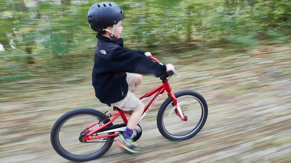 A boy biking on a trail